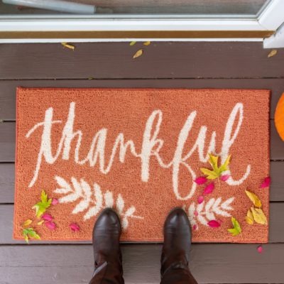 Welcome mat with the word "Thankful" on front doorstep